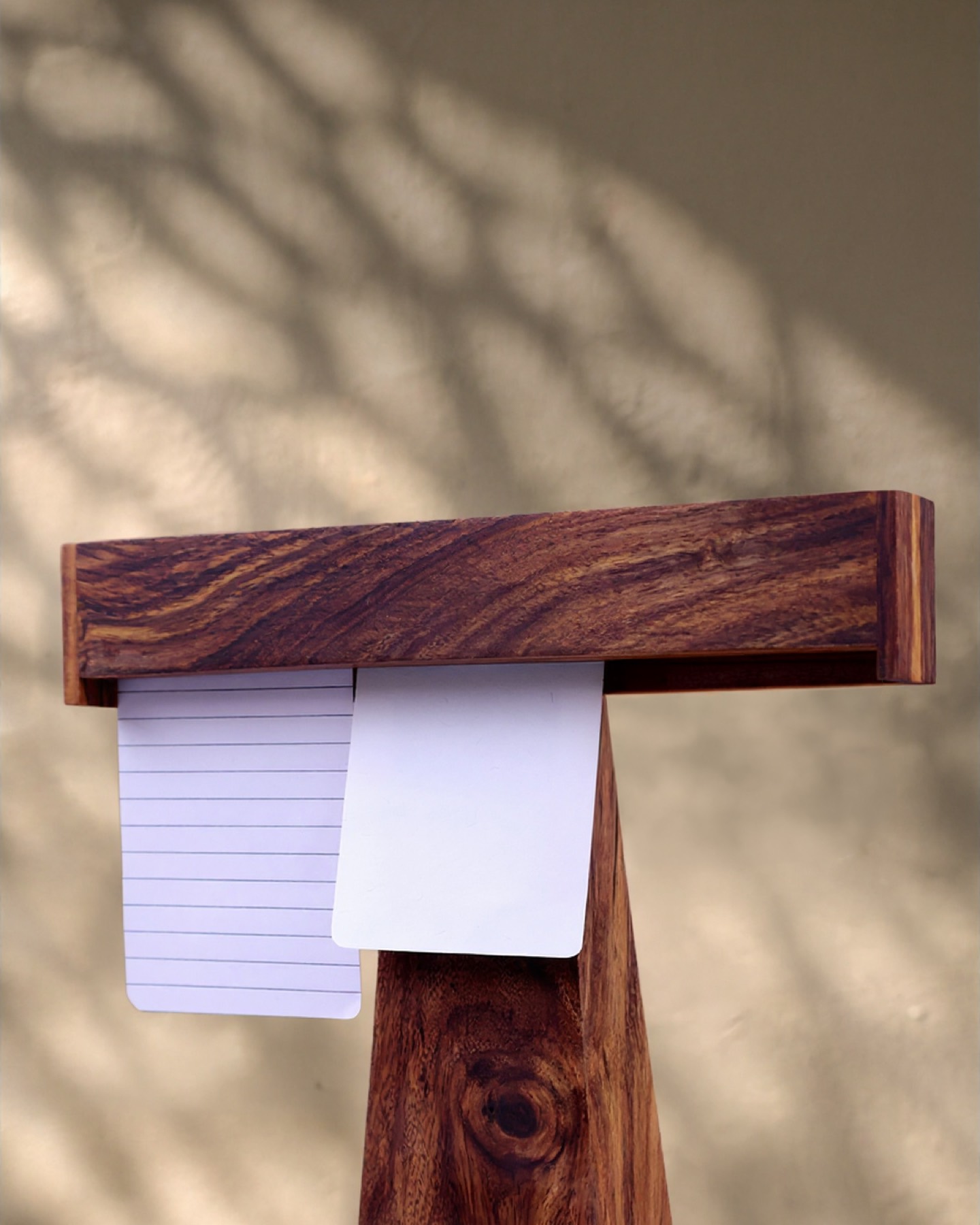 Two notes held at eye level in warm shadow