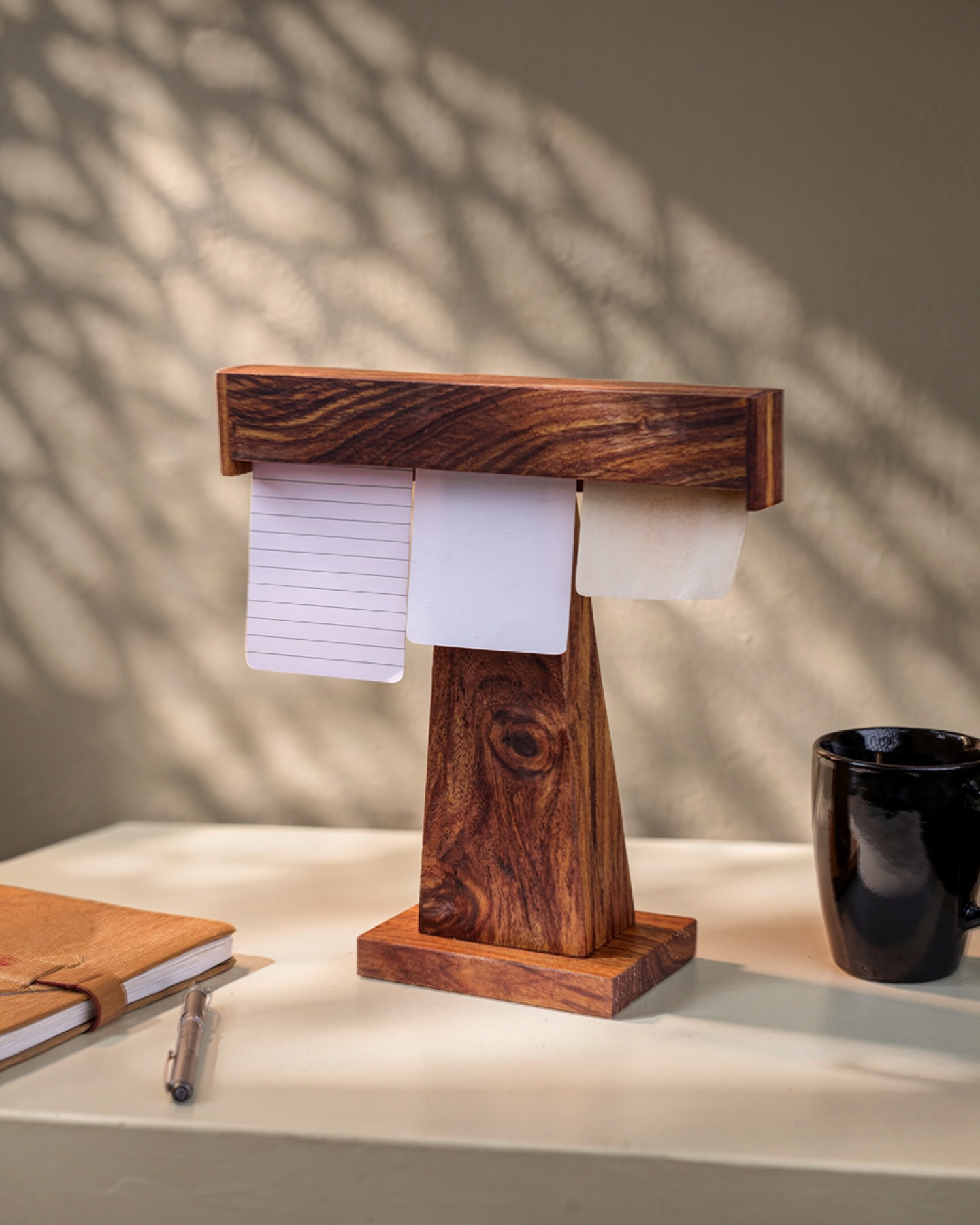 Display Dock on a desk in dappled light, holding three notes